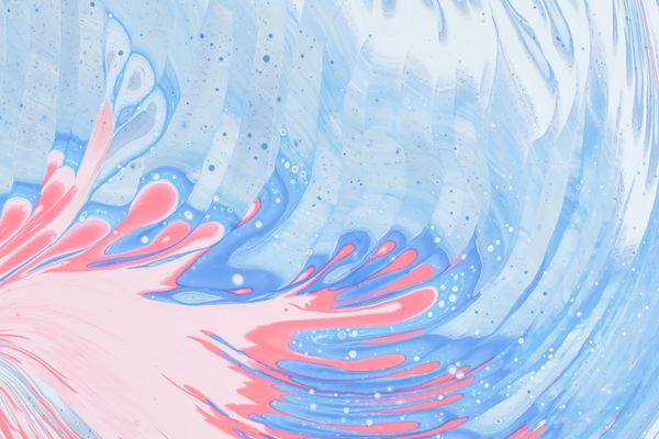 A swirl of pink. blue, and white paint moving from the bottom left corner to the top right of the image